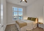 Thumbnail 23 of 23 - A bedroom with a bed, pillows, and a ceiling fan.