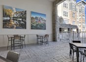 Thumbnail 4 of 23 - A patio with a table and chairs and two pictures on the wall.