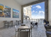 Thumbnail 12 of 23 - A patio with a table and chairs and a view of a building.