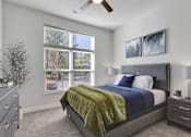Thumbnail 20 of 23 - A bedroom with a bed, nightstand, and window with blinds.