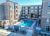Thumbnail 3 of 23 - A large apartment complex with a pool in the middle.