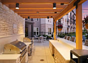 Thumbnail 13 of 35 - A patio with a grill and chairs is shown.