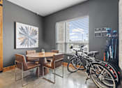 Thumbnail 29 of 35 - A room with a dining table and chairs and a bicycle.