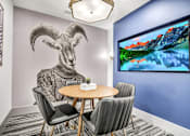 Thumbnail 9 of 43 - A room with a table, chairs, and a large screen displaying a mountain landscape.