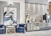 Thumbnail 11 of 43 - A modern living room with blue velvet chairs and a large abstract painting.