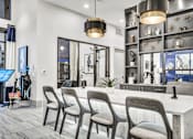 Thumbnail 12 of 43 - A modern salon with a white counter and grey chairs.