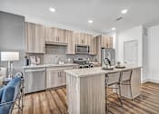 Thumbnail 26 of 43 - A modern kitchen with wooden cabinets and a central island.