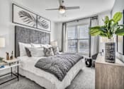 Thumbnail 27 of 43 - A bedroom with a large bed and a ceiling fan.