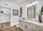 Thumbnail 29 of 43 - A bathroom with a toilet, sink, and mirror.