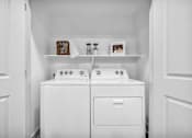 Thumbnail 36 of 43 - A white washing machine and dryer in a small laundry room.