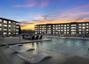 Thumbnail 41 of 43 - A modern pool area with a large rectangular pool and a smaller wavy pool next to it.