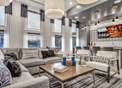 Thumbnail 4 of 43 - A modern living room with a grey sofa, a wooden coffee table, and a large painting on the wall.
