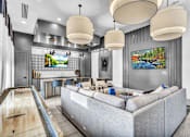 Thumbnail 5 of 43 - A modern living room with a grey couch and a pool table.