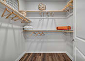 Thumbnail 39 of 53 - A white closet with wooden hangers and a basket on top.
