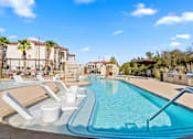 Thumbnail 29 of 92 - A large swimming pool with a slide and sun loungers.