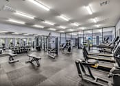 Thumbnail 33 of 92 - A spacious gym with a variety of equipment including treadmills, weights, and benches.