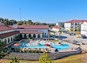 Thumbnail 19 of 92 - A large building with a pool in front of it.