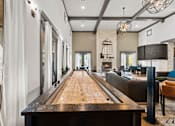 Thumbnail 52 of 92 - A long wooden table is in the middle of a room with a shiny floor.
