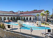 Thumbnail 20 of 92 - A large white building with a red roof and a pool in front.