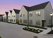 Thumbnail 21 of 63 - A series of modern buildings with a parking lot in front.