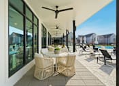 Thumbnail 10 of 63 - A patio with a table and chairs and a ceiling fan.