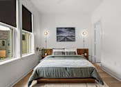 Thumbnail 41 of 63 - A bedroom with a large bed and a painting on the wall.