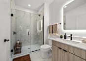 Thumbnail 58 of 63 - A modern bathroom with a glass shower and a white toilet.