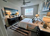 Thumbnail 10 of 10 - A bedroom with a large bed, a dresser, and a ceiling fan.