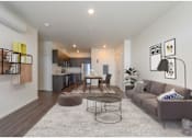 Thumbnail 1 of 13 - A modern living room with a grey sofa and a coffee table.