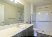 Thumbnail 7 of 13 - A bathroom with a white sink and a white toilet.