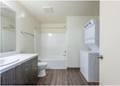 Thumbnail 9 of 13 - A white bathroom with a toilet, sink, and shower.