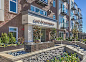 Thumbnail 34 of 39 - Lux Apartments Bellevue WA entryway with fountain and landscaped garden beds
