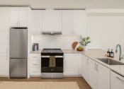 Thumbnail 2 of 23 - a white kitchen with stainless steel appliances and white cabinets at Liza Apartments, Seattle