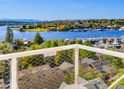 Thumbnail 5 of 23 - a balcony with two chairs and a table overlooking a body of water at Liza Apartments, Seattle, Washington, 98102