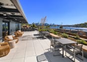 Thumbnail 13 of 23 - a patio with tables and chairs and a view of the city at Liza Apartments, Seattle