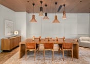 Thumbnail 18 of 23 - a dining room with a wooden table and chairs and hanging lamps at Liza Apartments, Washington