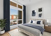 Thumbnail 5 of 22 - A bedroom with a large bed and a view of a cityscape through the window.