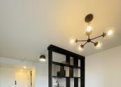 Thumbnail 3 of 10 - a black shelving unit in the center of a living room with wood flooring