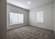 Thumbnail 4 of 6 - A room with carpeted floor and two windows with blinds.