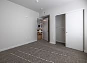 Thumbnail 5 of 6 - A room with a carpeted floor and two white doors.