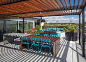 Thumbnail 18 of 35 - A wooden table with blue chairs is on a patio.