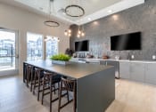 Thumbnail 20 of 30 - a large kitchen with a long island with chairs and a tv