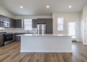 Thumbnail 8 of 30 - an empty kitchen with a large island in the middle of it