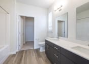 Thumbnail 10 of 30 - a bathroom with a large mirror and a sink and a toilet