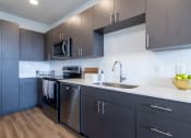 Thumbnail 5 of 30 - a modern kitchen with stainless steel appliances and gray cabinets