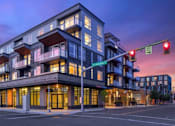 Thumbnail 1 of 35 - A modern multi-story building with a balcony on the second floor.