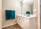 Thumbnail 15 of 16 - A bathroom with a white counter and a mirror.