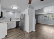 Thumbnail 2 of 34 - an empty kitchen with white cabinets and a stainless steel refrigerator