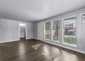 Thumbnail 1 of 34 - an empty living room with windows and wood floors