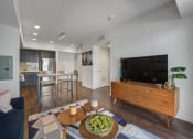 Thumbnail 27 of 28 - Hollywood Apartments for Rent - The Fifty Five Fifty - A Spacious And Bright Living Room With Wood-Style Flooring And Room For A Couch, A Coffee Table, And A Large Entertainment Center